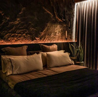 bedroom with blackout curtains and stone walls